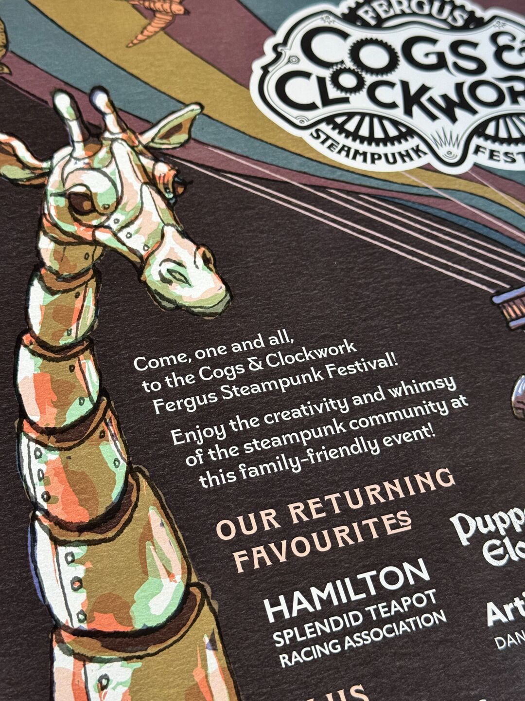 Centre left detail of the Cogs and Clockwork 2025 festival promotion illustrated poster focusing a mechanical giraffe. Poster features the festival ringmaster saluting this giraffe from a floating hot air balloon.