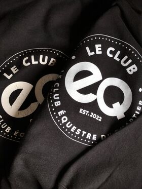 Detail of two Le Club EQ Hoodies in black with white logo laying on top of each other